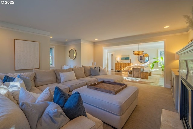 carpeted living room with ornamental molding and a fireplace