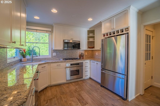3190 SW Ridgewood Ave, Portland, OR 97225 - kitchen with appliances with stainless steel finishes, light wood-style flooring, open shelves, white cabinets, and recessed lighting