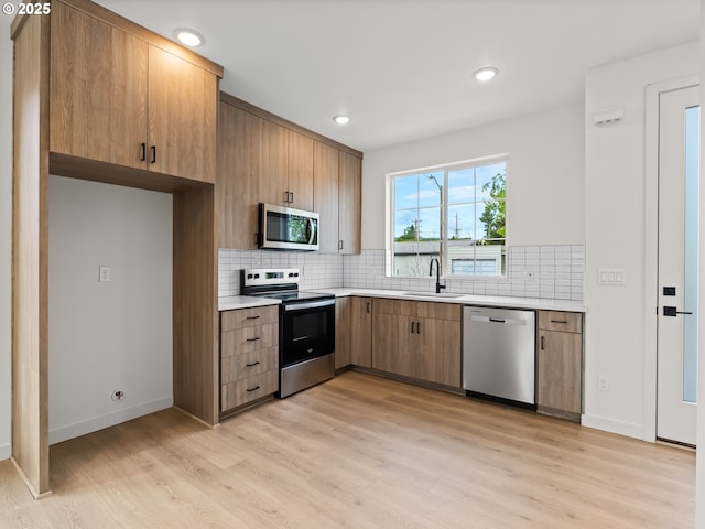 7582 N Alma Ave Unit 4, Portland, OR 97203 - kitchen featuring stainless steel appliances, a sink, light wood-type flooring, light countertops, and recessed lighting