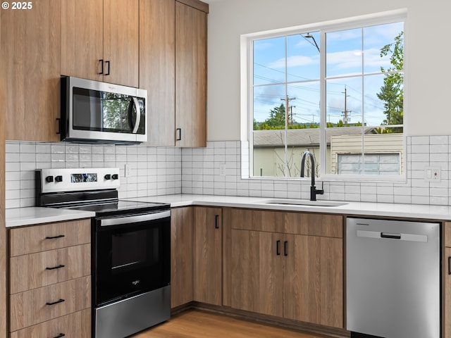 7582 N Alma Ave Unit 4, Portland, OR 97203 - kitchen with stainless steel appliances, a sink, light countertops, and decorative backsplash