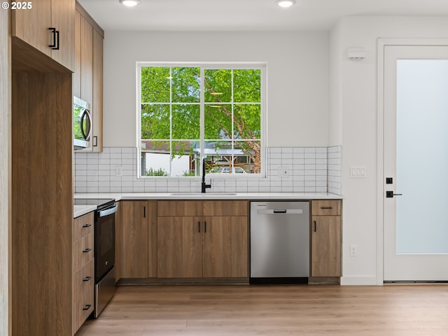 7582 N Alma Ave Unit 4, Portland, OR 97203 - kitchen featuring appliances with stainless steel finishes, light countertops, backsplash, a sink, and recessed lighting