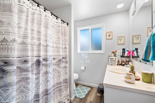 bathroom with vanity, hardwood / wood-style floors, walk in shower, and toilet