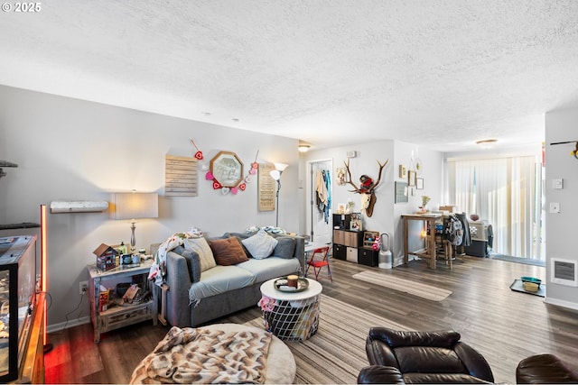 living room with a textured ceiling and dark hardwood / wood-style flooring