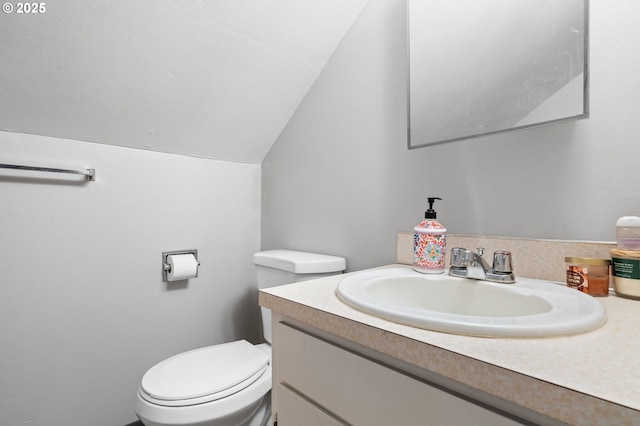 bathroom featuring vaulted ceiling, vanity, and toilet