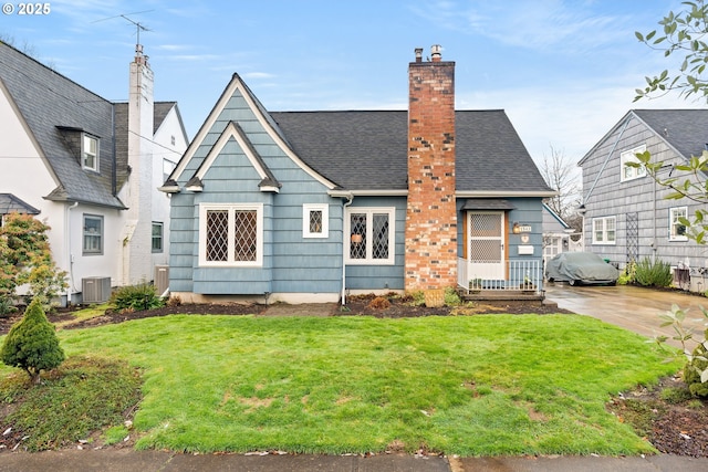 back of house featuring a lawn and central AC unit