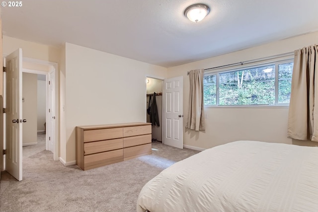 bedroom with light colored carpet and baseboards
