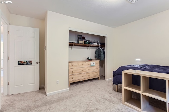 bedroom featuring light colored carpet, a closet, and baseboards