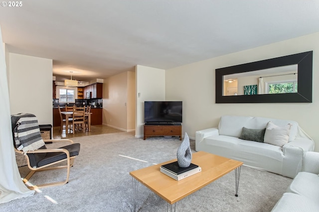 living room featuring carpet and baseboards