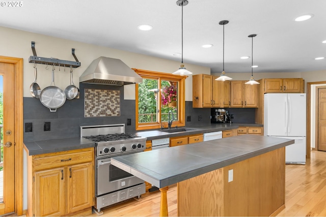 kitchen featuring white appliances, a sink, extractor fan, tasteful backsplash, and recessed lighting