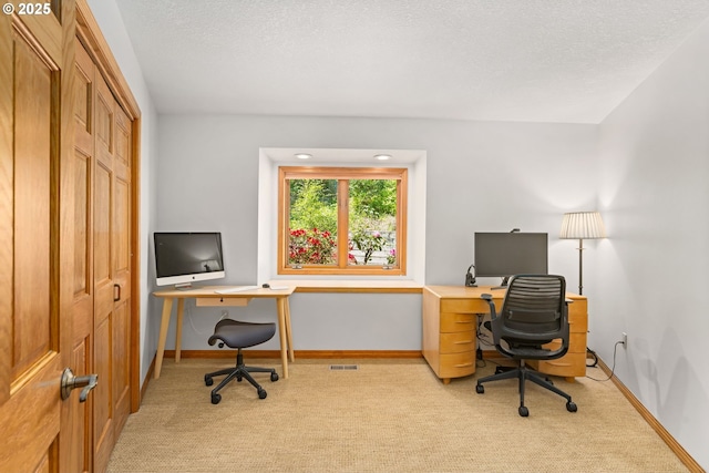 office featuring carpet floors, baseboards, and a textured ceiling