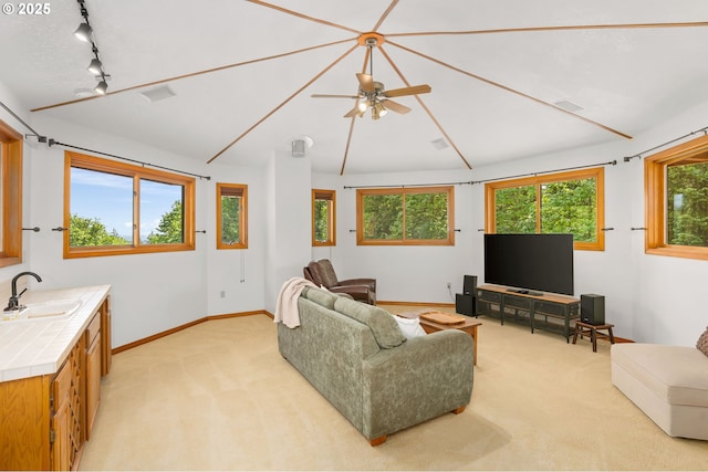 living room with light carpet, baseboards, ceiling fan, track lighting, and vaulted ceiling