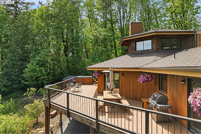 deck featuring a hot tub and a grill