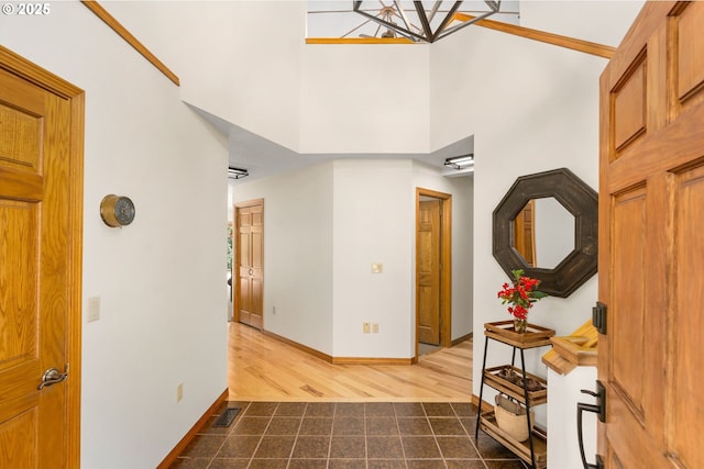 entryway with a high ceiling, dark wood-style flooring, and baseboards