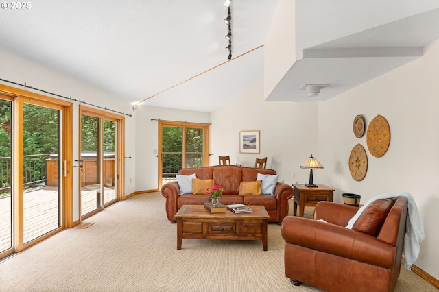 living area with light colored carpet, vaulted ceiling, and baseboards