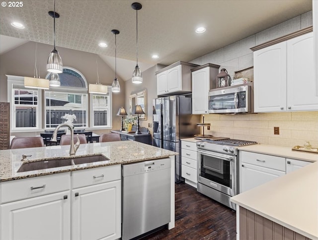 5610 NE Going St, Portland, OR 97218 - kitchen with appliances with stainless steel finishes, a sink, dark wood finished floors, lofted ceiling, and pendant lighting