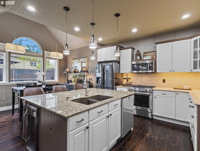 5610 NE Going St, Portland, OR 97218 - kitchen with appliances with stainless steel finishes, a sink, beverage cooler, a center island with sink, and dark wood-style flooring