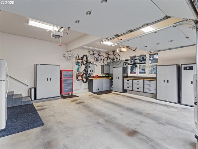 5610 NE Going St, Portland, OR 97218 - garage featuring a garage door opener, a workshop area, freestanding refrigerator, and electric panel
