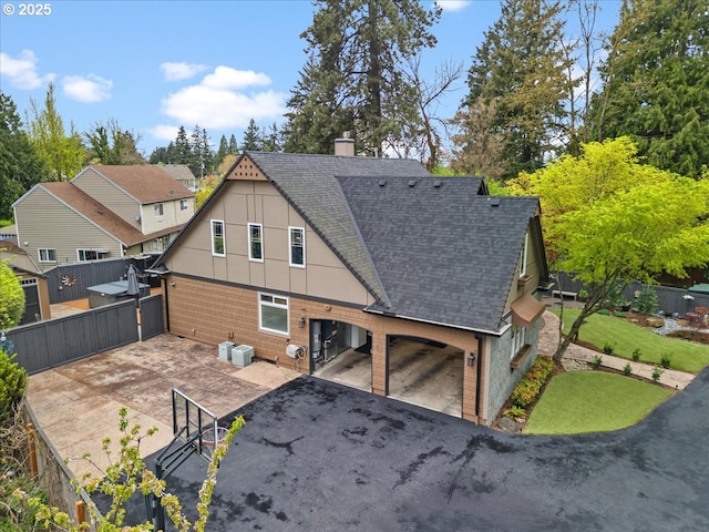 5610 NE Going St, Portland, OR 97218 - rear view of property featuring roof with shingles, a chimney, and a patio area