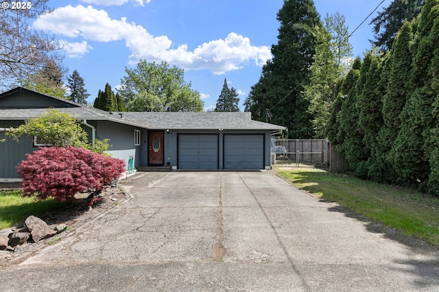 view of front of home with driveway, a garage, and fence