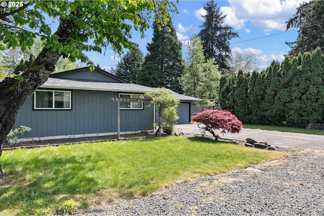 view of property exterior with concrete driveway, a lawn, and a garage