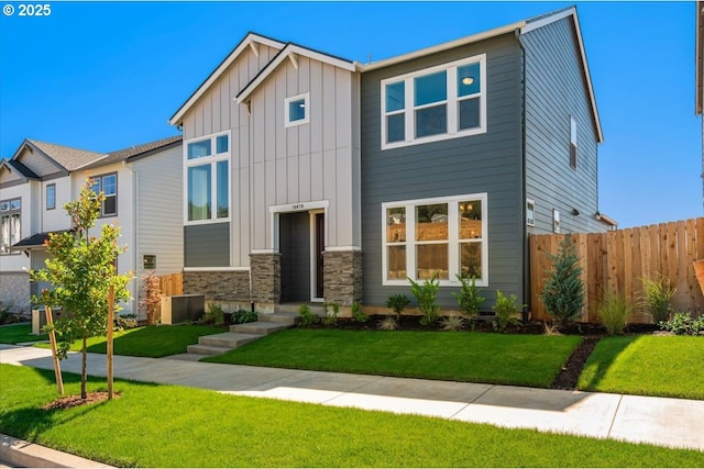 craftsman house with stone siding, fence, a front lawn, and board and batten siding