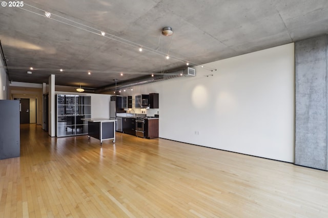 unfurnished living room with light wood finished floors and a sink