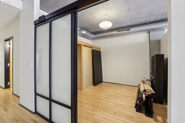 hall with visible vents and light wood-type flooring