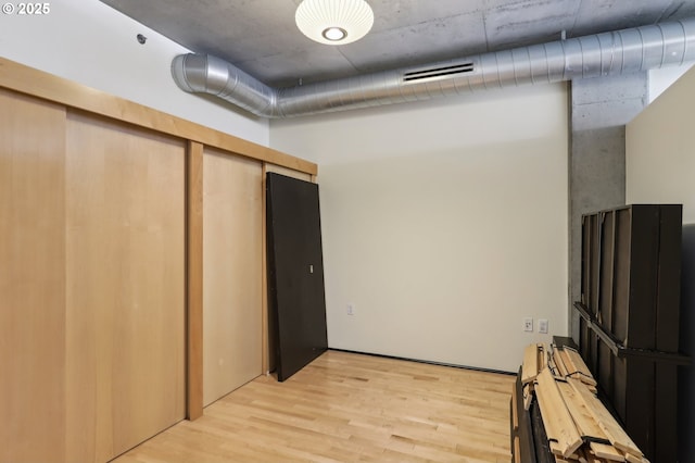 finished basement with visible vents and light wood-type flooring