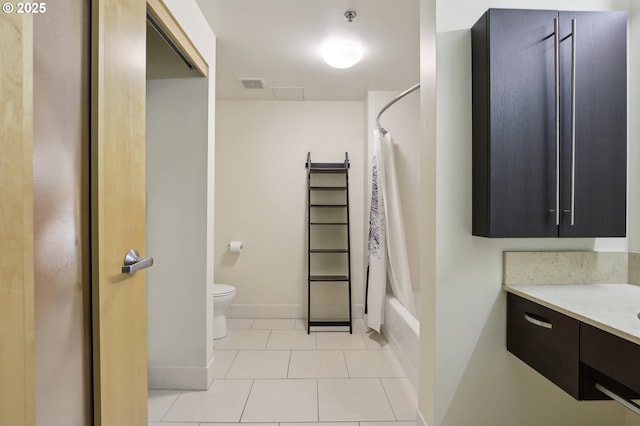 bathroom featuring tile patterned flooring, baseboards, toilet, shower / bath combination with curtain, and vanity