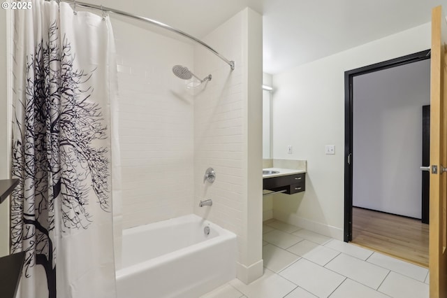 bathroom with tile patterned flooring, shower / bathtub combination with curtain, and baseboards