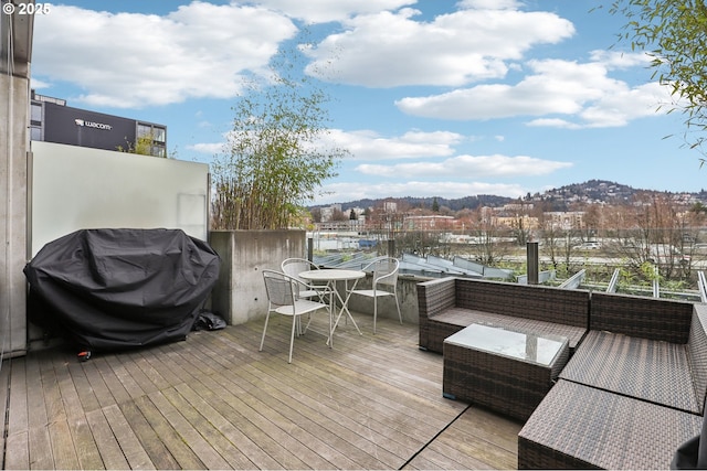 deck with an outdoor living space, grilling area, and a mountain view