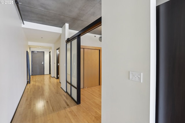 hall featuring a barn door and light wood-style flooring