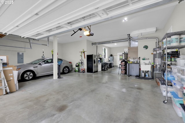 1910 S 15th Cir, Ridgefield, WA 98642 - garage with a garage door opener, stainless steel fridge, electric panel, and gas water heater