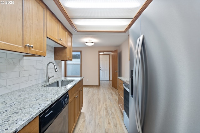 251 NE Village Squire Ave Unit 15, Gresham, OR 97030 - kitchen with appliances with stainless steel finishes, a sink, light wood-type flooring, tasteful backsplash, and light stone countertops
