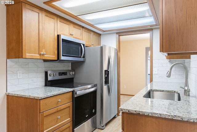 251 NE Village Squire Ave Unit 15, Gresham, OR 97030 - kitchen with appliances with stainless steel finishes, a sink, backsplash, and light stone counters