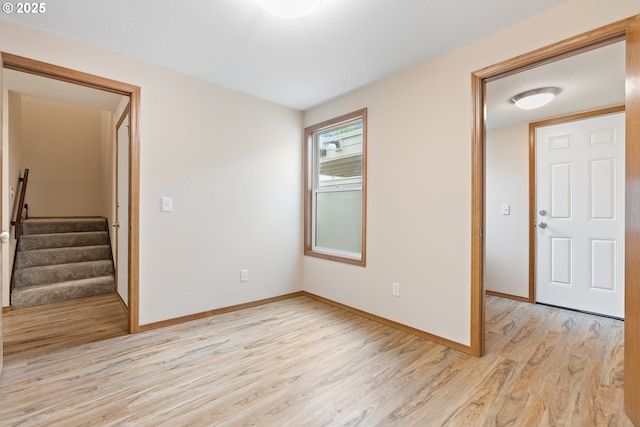 251 NE Village Squire Ave Unit 15, Gresham, OR 97030 - unfurnished room with light wood-type flooring, baseboards, and stairway