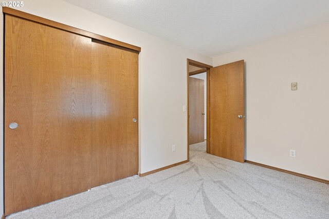 251 NE Village Squire Ave Unit 15, Gresham, OR 97030 - unfurnished bedroom featuring a closet, carpet floors, and baseboards