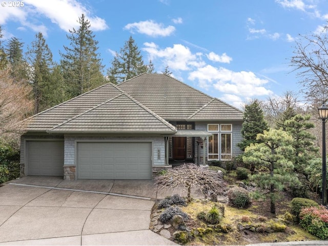 view of front facade featuring stone siding, concrete driveway, and a garage