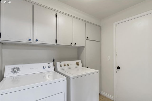 washroom featuring washer and dryer, cabinet space, and light tile patterned flooring