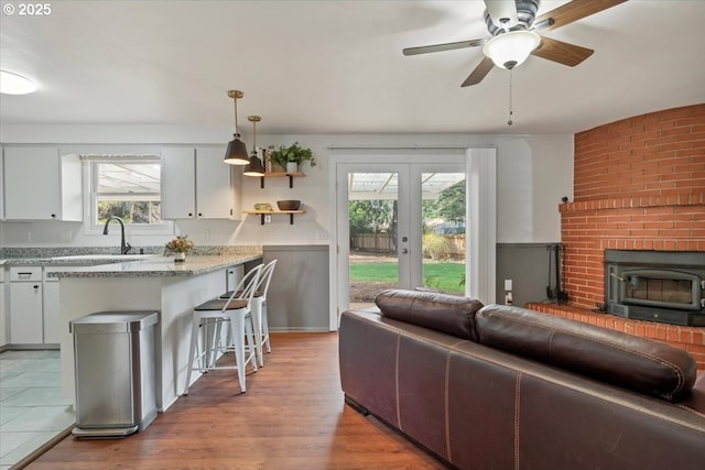 living area featuring light wood-type flooring, french doors, and ceiling fan
