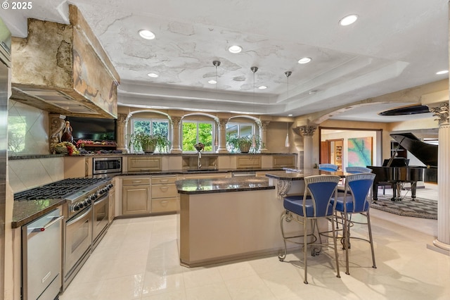 6421 Brooklake Rd, Salem, OR 97305 - kitchen with a center island, arched walkways, a raised ceiling, appliances with stainless steel finishes, and a kitchen breakfast bar