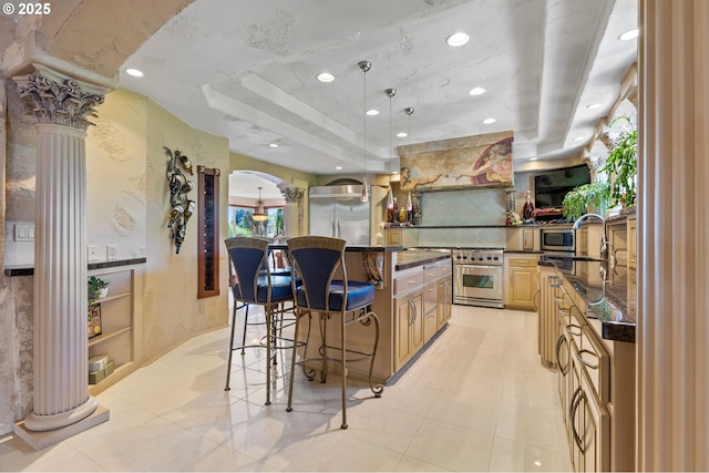 6421 Brooklake Rd, Salem, OR 97305 - kitchen with ornate columns, a sink, stainless steel appliances, a breakfast bar area, and a center island