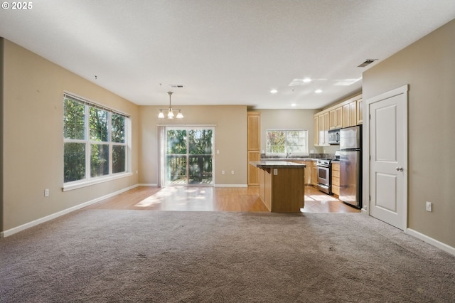 22864 SW Forest Creek Dr Unit 200, Sherwood, OR 97140 - kitchen with visible vents, light carpet, a chandelier, appliances with stainless steel finishes, and open floor plan