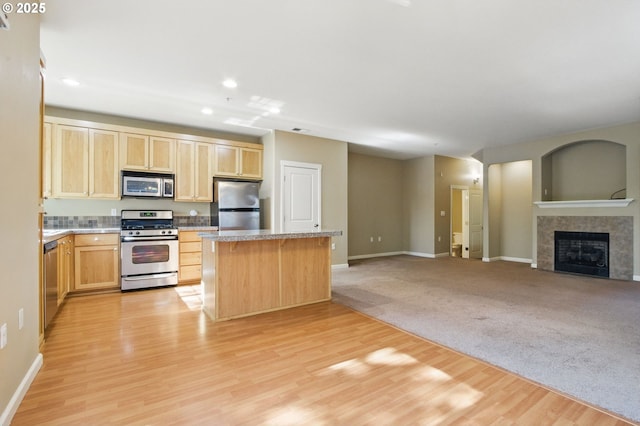 22864 SW Forest Creek Dr Unit 200, Sherwood, OR 97140 - kitchen featuring a center island, open floor plan, light brown cabinetry, light wood-style flooring, and appliances with stainless steel finishes