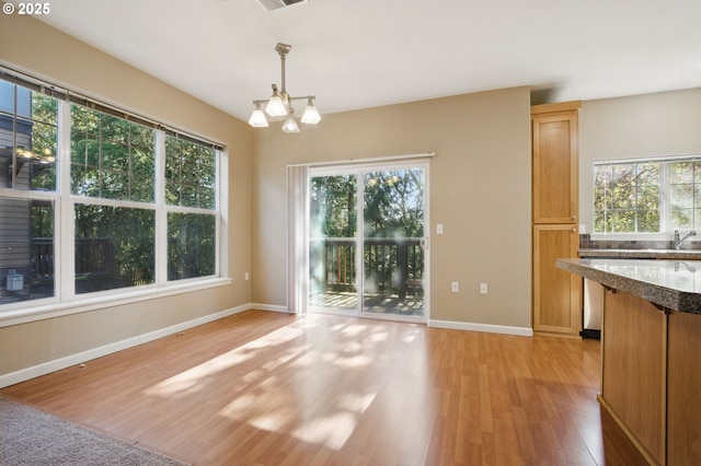22864 SW Forest Creek Dr Unit 200, Sherwood, OR 97140 - unfurnished dining area with a chandelier, plenty of natural light, and light wood finished floors