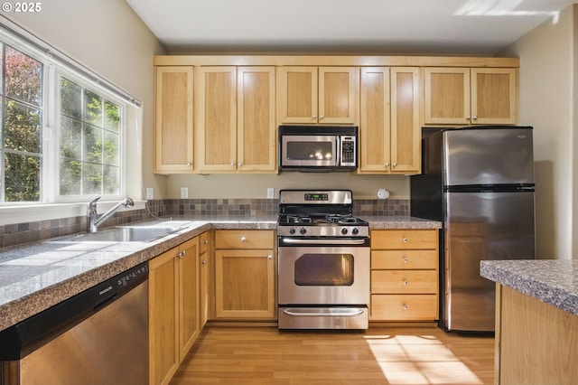 22864 SW Forest Creek Dr Unit 200, Sherwood, OR 97140 - kitchen featuring light brown cabinetry, stainless steel appliances, tile countertops, a sink, and light wood-style flooring