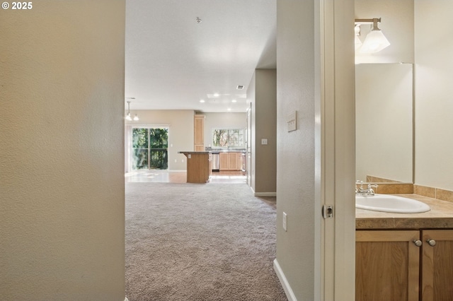 22864 SW Forest Creek Dr Unit 200, Sherwood, OR 97140 - hallway featuring carpet, a textured wall, visible vents, a sink, and baseboards