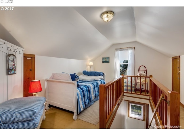 bedroom with wood finished floors and vaulted ceiling
