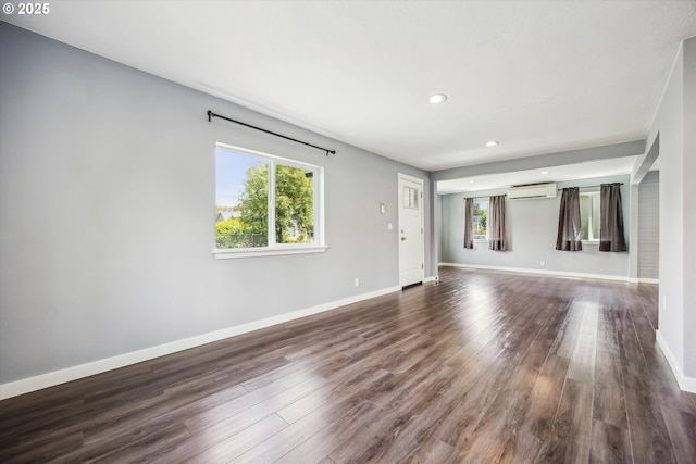 63 S 22nd St, Saint Helens, OR 97051 - empty room featuring an AC wall unit, baseboards, recessed lighting, and dark wood-style floors