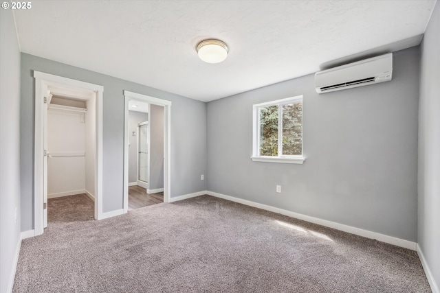 63 S 22nd St, Saint Helens, OR 97051 - unfurnished bedroom featuring a wall unit AC, carpet flooring, a spacious closet, and baseboards